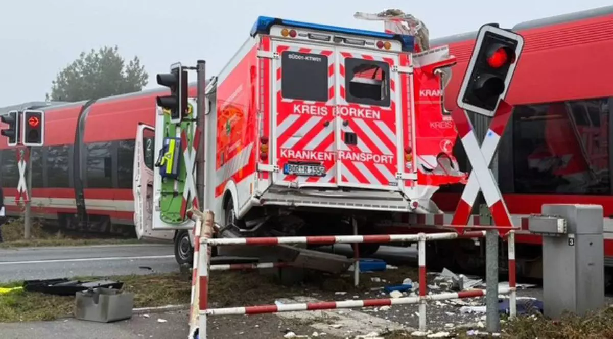 Un tren regional , rosu, loveste o ambulanta, cu rosu si alb, care era stationata pe calea ferata, 30 septembrie 2025, Germania