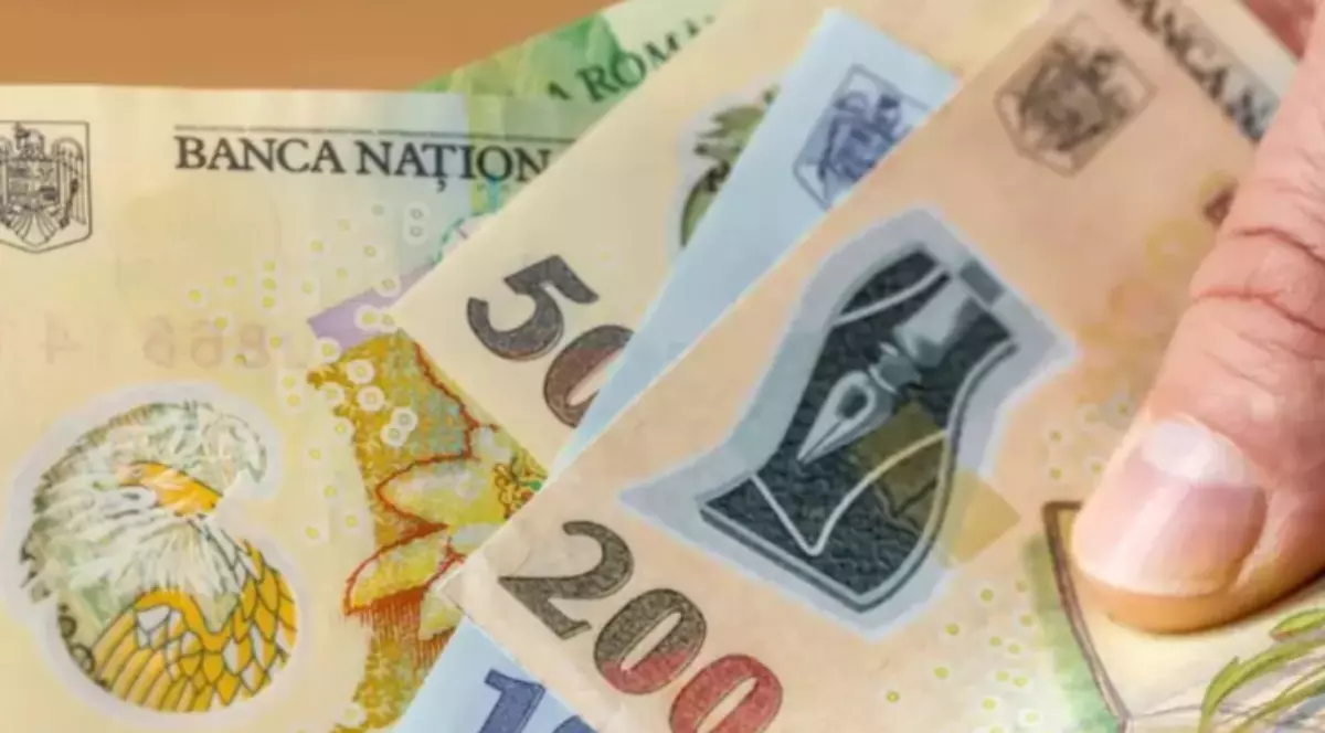 O persoană care ține în mână bancnote în lei