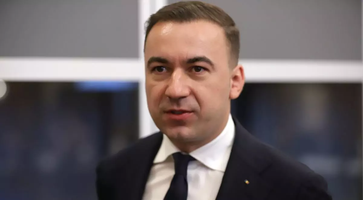 Ministrul Energiei, Bogdan Ivan, îmbrăcat la costum negru, cămașă albă și cravată.