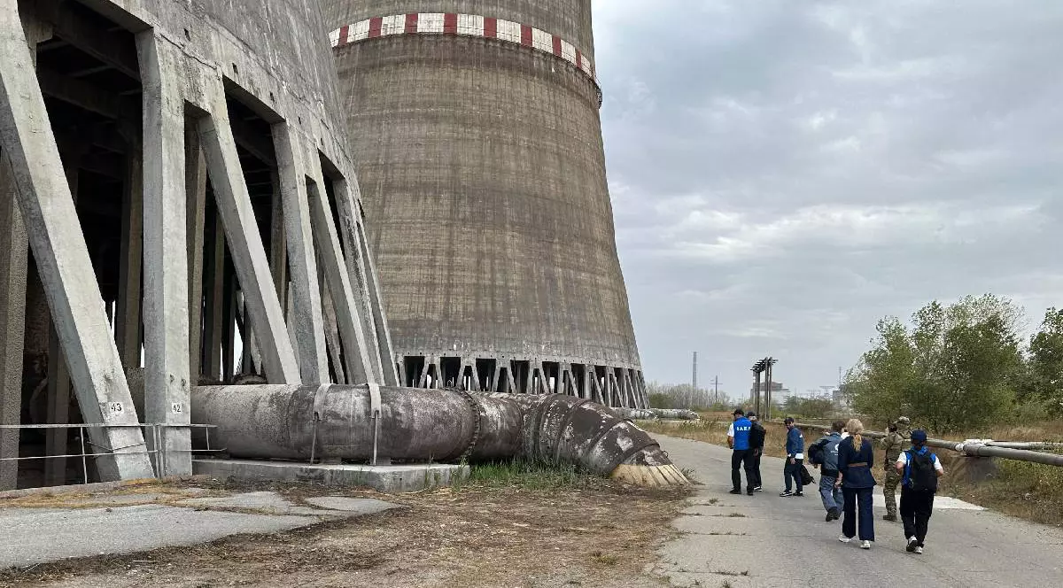 În imagine se văd niște oameni afalați la baza centralei nucleare Zaporojie din Ucraina. În acest moment centrala funcționează doar cu ajutorul unor generatoare de urgență