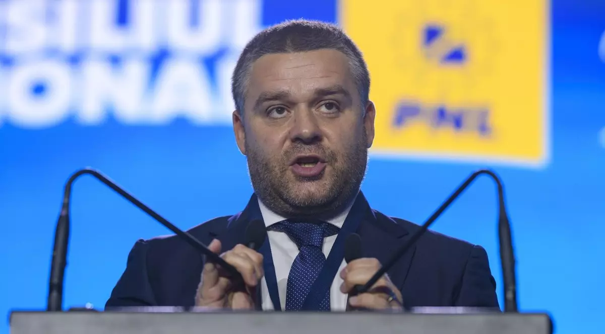 Ciprian Ciucu într-un sacou negru în timp ce vorbește la microfon.