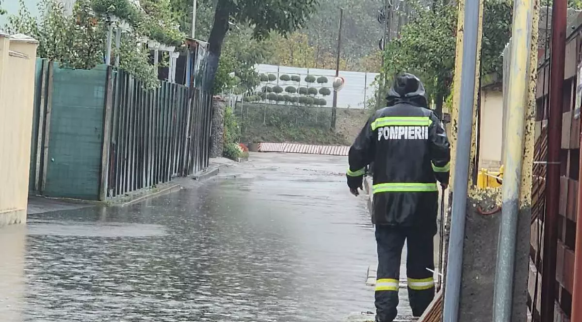 Un pompier în timpul intervenției în timp ce afară plouă neîncetat
