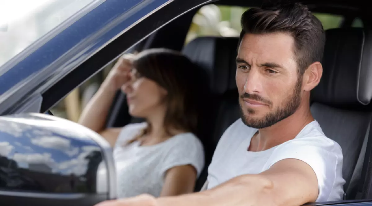 Cum să-ţi reglezi corect oglinzile maşinii ca să elimini unghiurile moarte – Un șofer reglează oglindă laterală a mașinii