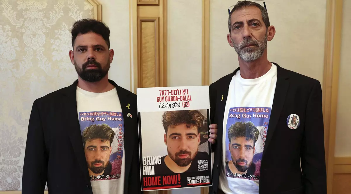 Fratele Gal, stânga, și tatăl Ilan Gilboa-Dalal, cu portretul lui Guy, ostatic Hamas de peste doi ani