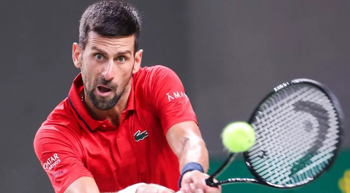 Novak Djokovici, îmbrăcat într-un tricou roșu, returnează o minge în timpul unie meci din cadrul turneului de la Shanghai, China, octombrie 2025