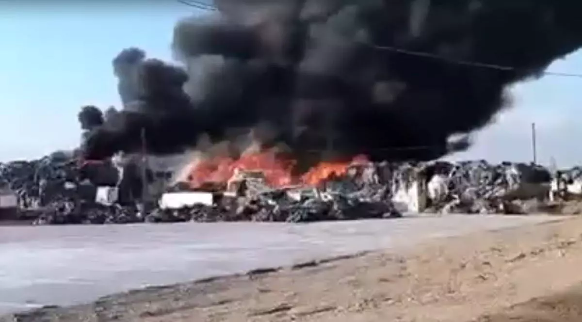 Sute de deșeuri ard într-o curte din Prahova, se vede cum deșeurile au fost cuprinse de flăcări, deasupra iese un nor de fum dens și negru