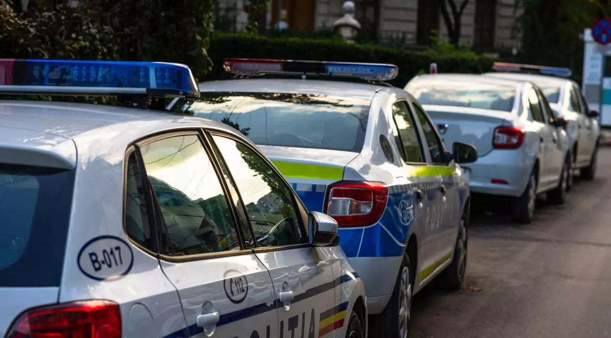 Mai multe mașini de Poliție, ale angajaților care lucrează în Ministerul de Interne, cu girofarurile oprite, stând parcate pe marginea drumului