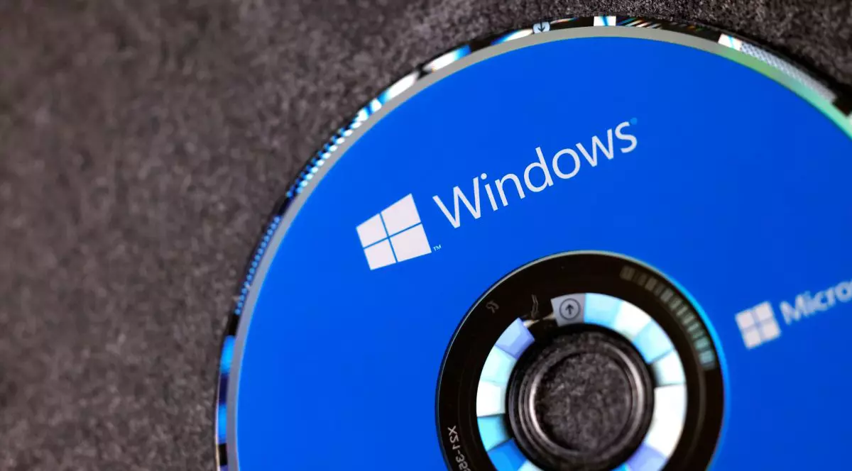 Un CD albastru de instalare cu Microsoft Windows 10, așezat pe o masă.