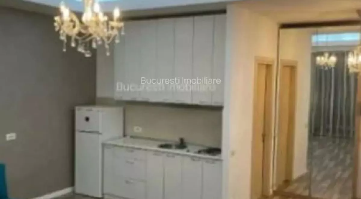 Garsonieră București. În imagine se vede un dulap de bucatarie, usa si o oglinda mare pe perete