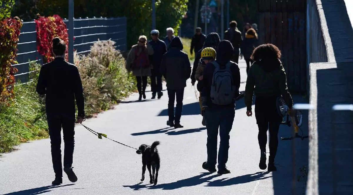 Oameni din Berlin în timp ce se plimbă pe stradă, într-o zi însorită de octombrie