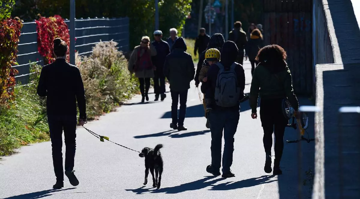 Oameni din Berlin în timp ce se plimbă pe stradă, într-o zi însorită de octombrie