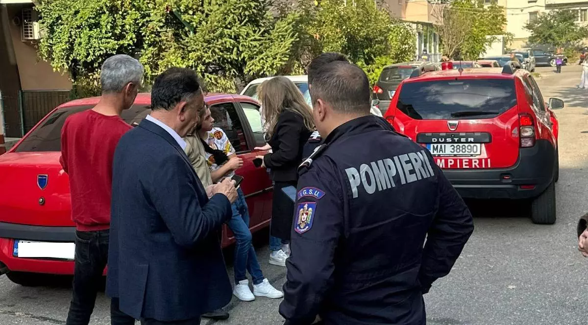 Unele dintre persoanele evacuate din blocul din Mioveni, în timp ce discută cu autoritățile prezente la fața locului, pompierii au intervenit de urgență