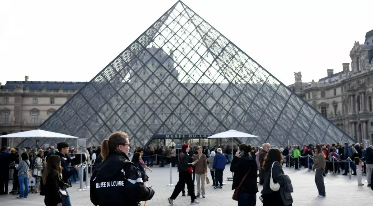 Polițiștii și turiști stând în fața Muzeului Luvru din Paris, oamenii legii păzesc intrările