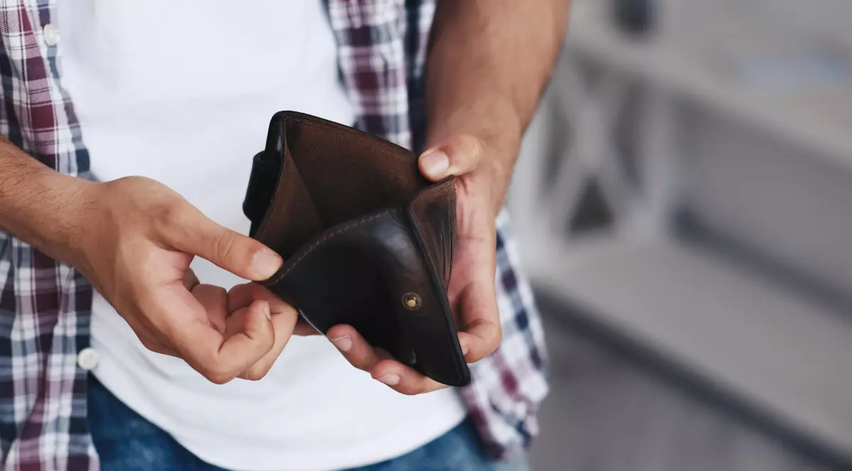 Un bărbat care ține în mână un portofel gol