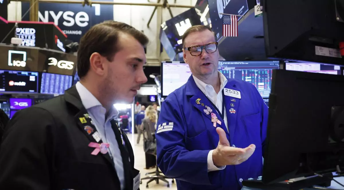 Traderi lucrează pe ringul Bursei de Valori din New York de pe Wall Street, vineri, 10 octombrie 2025