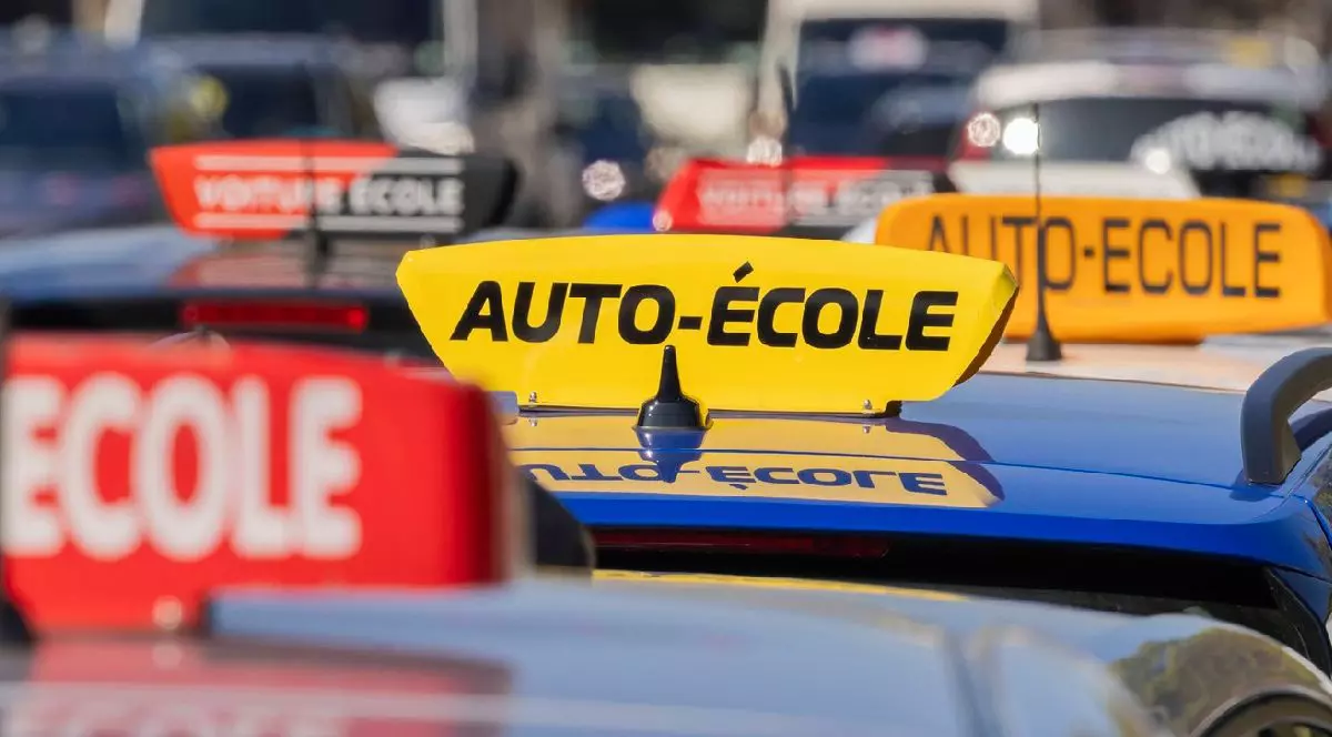 Mai multe mașini pe plafonul cărora se află casete pe care scrie școală de șoferi