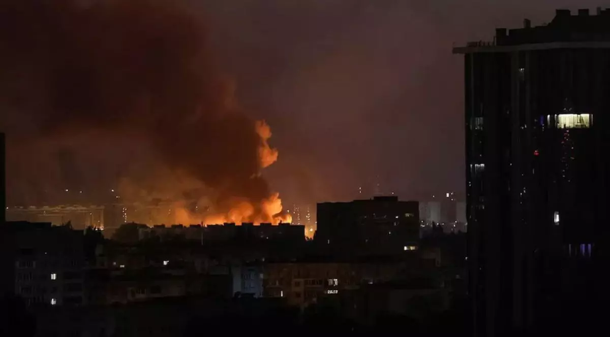 Un incendiu se vede în depărtare, în timpul nopții, la Kiev, după ce rușii au bombardat cu drone Shahed, 21-22 octombrie 2025