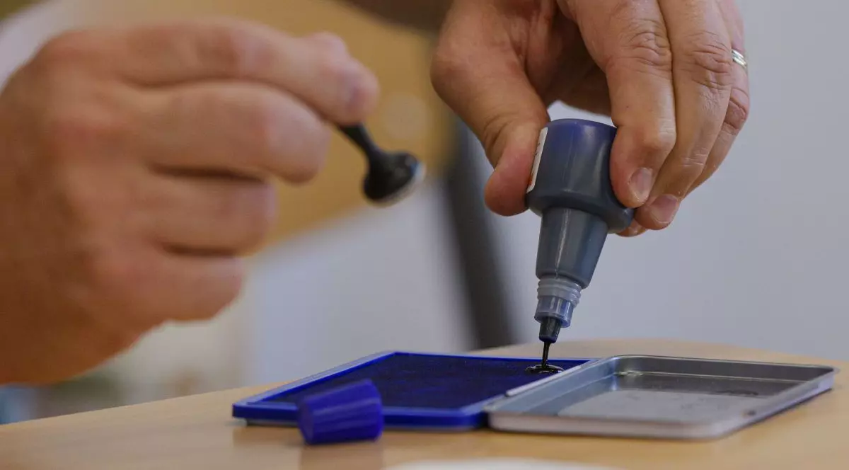 Un barbat toarna cerneala pe o tusiera in timpul alegerilor locale si europarlamentare, intr-o sectie de votare din Bucuresti, duminica, 9 iunie 2024