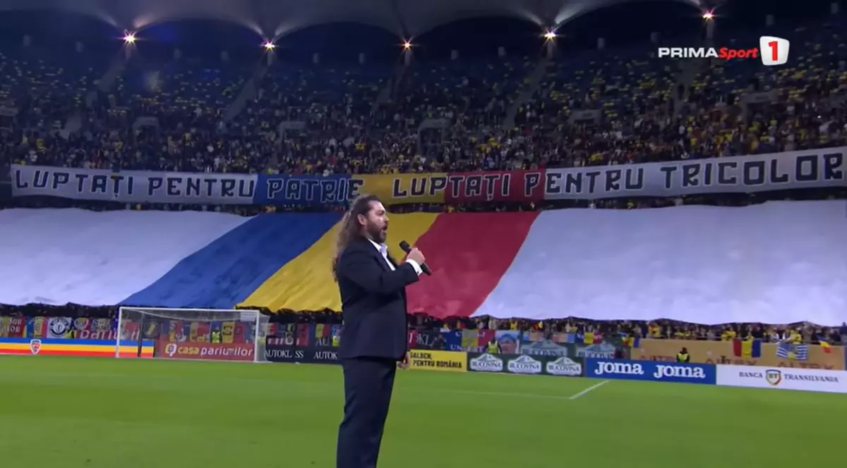 Tenorul Teodor Ilincăi a cântat imnul „Deșteaptă-te, române!” înaintea meciului cu Austria, câștigat de România cu scorul de 1-0, pe Arena Națională din București | Foto: captură YouTube - Prima Sport