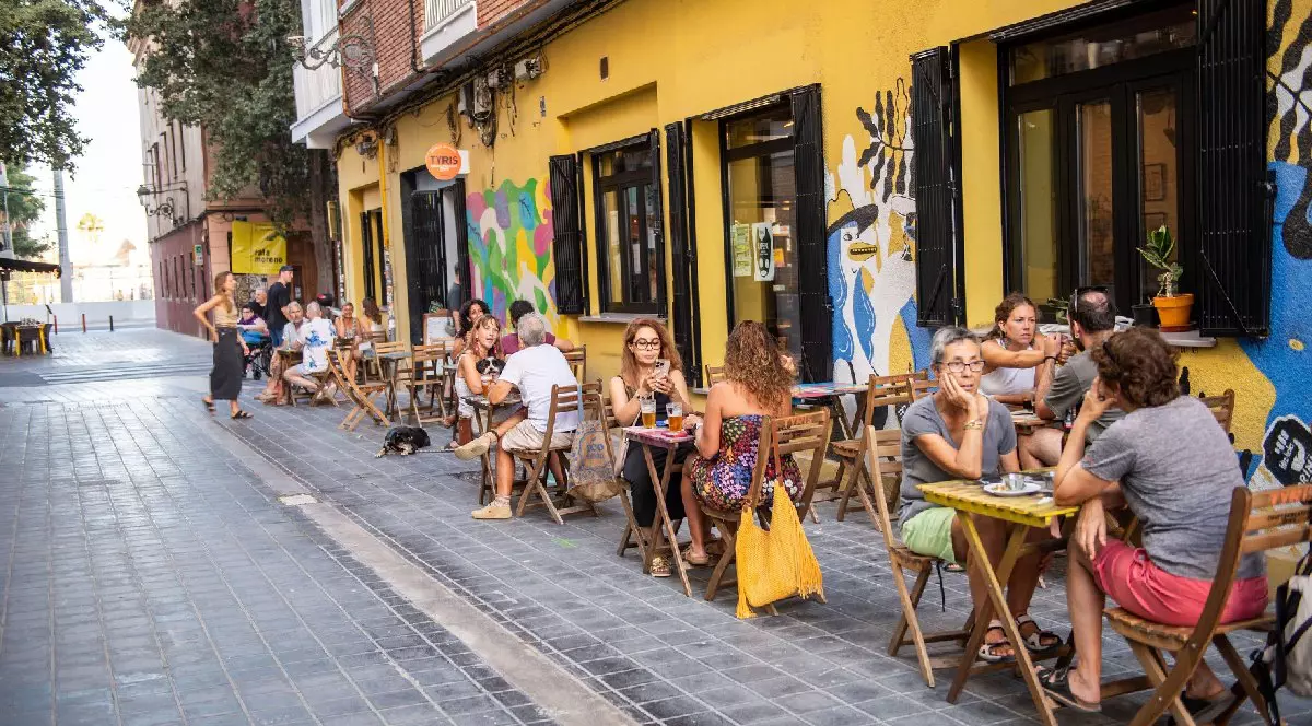 Oameni stând la o cafenea într-o zonă pietonală din Valencia, Spania