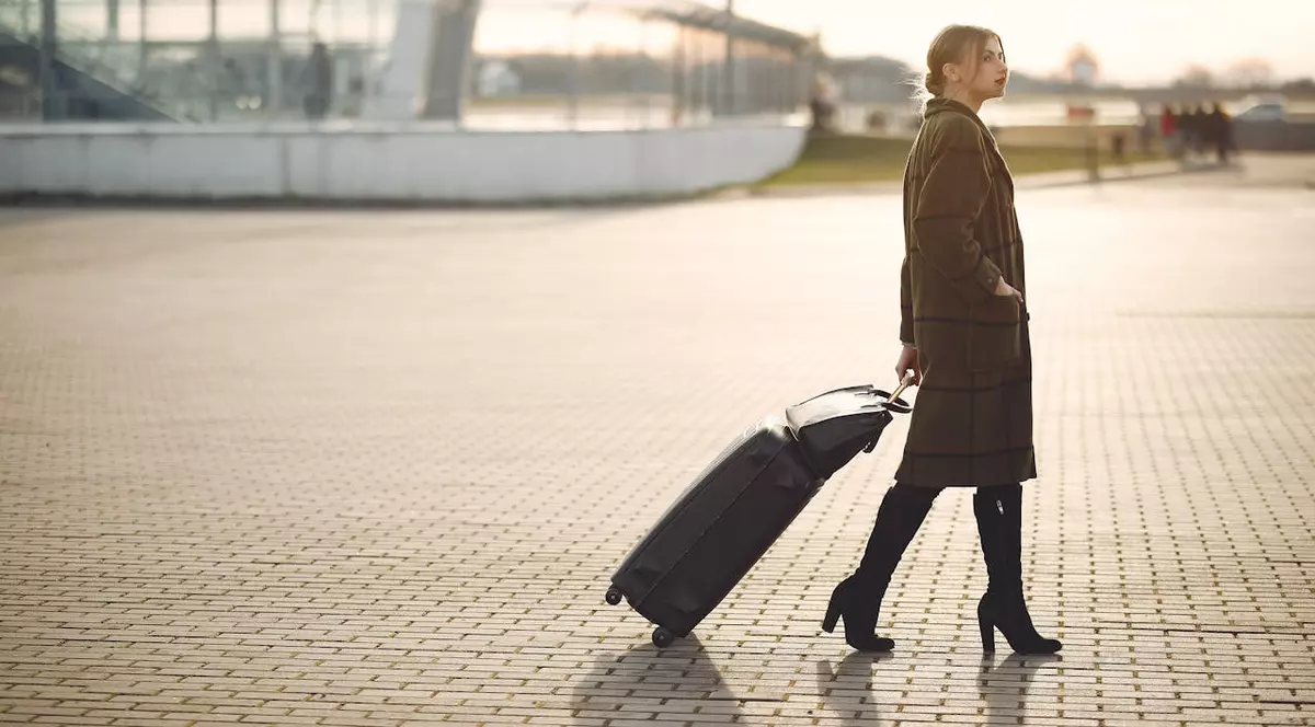 Femeie in aeroport trage un troller