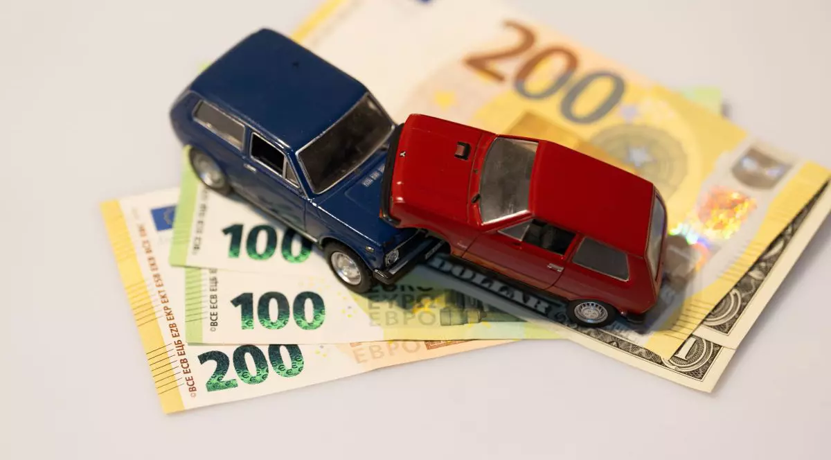 Imagine creativă cu două mașini de jucărie, una albastră și alta roșie, una peste alta, și împreună peste mai multe bancnote de 100 și 200 de euro