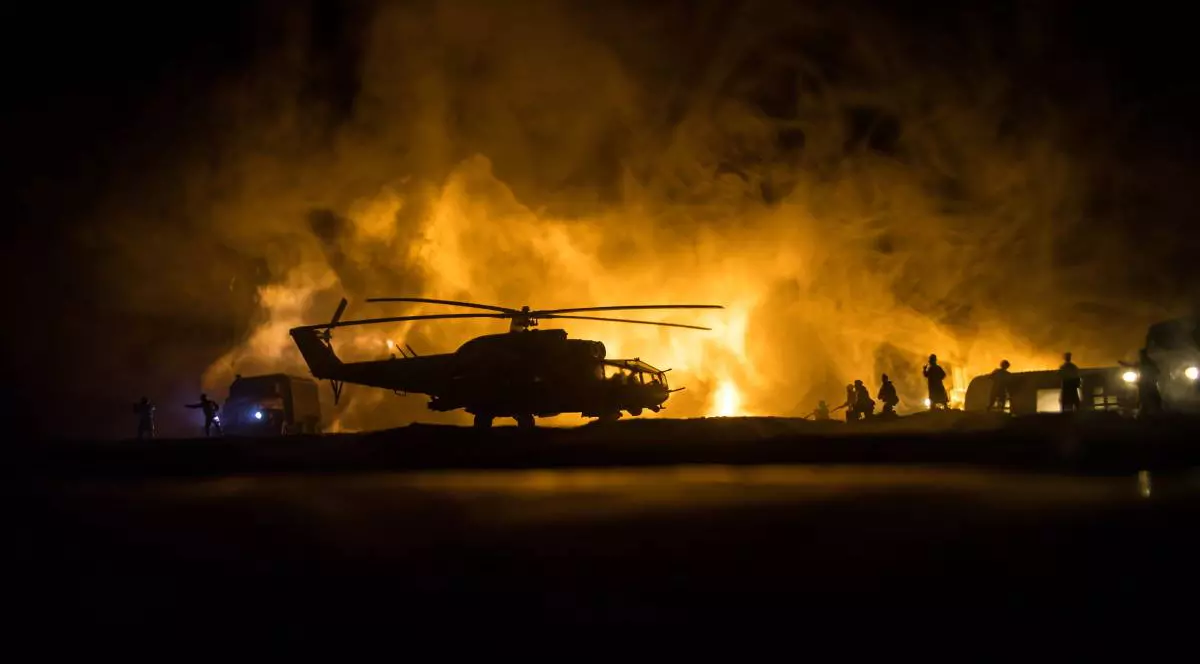 Incendiu după un atac rusesc, un elicopter de stingere stă parcat, în timp ce pompierii intervin