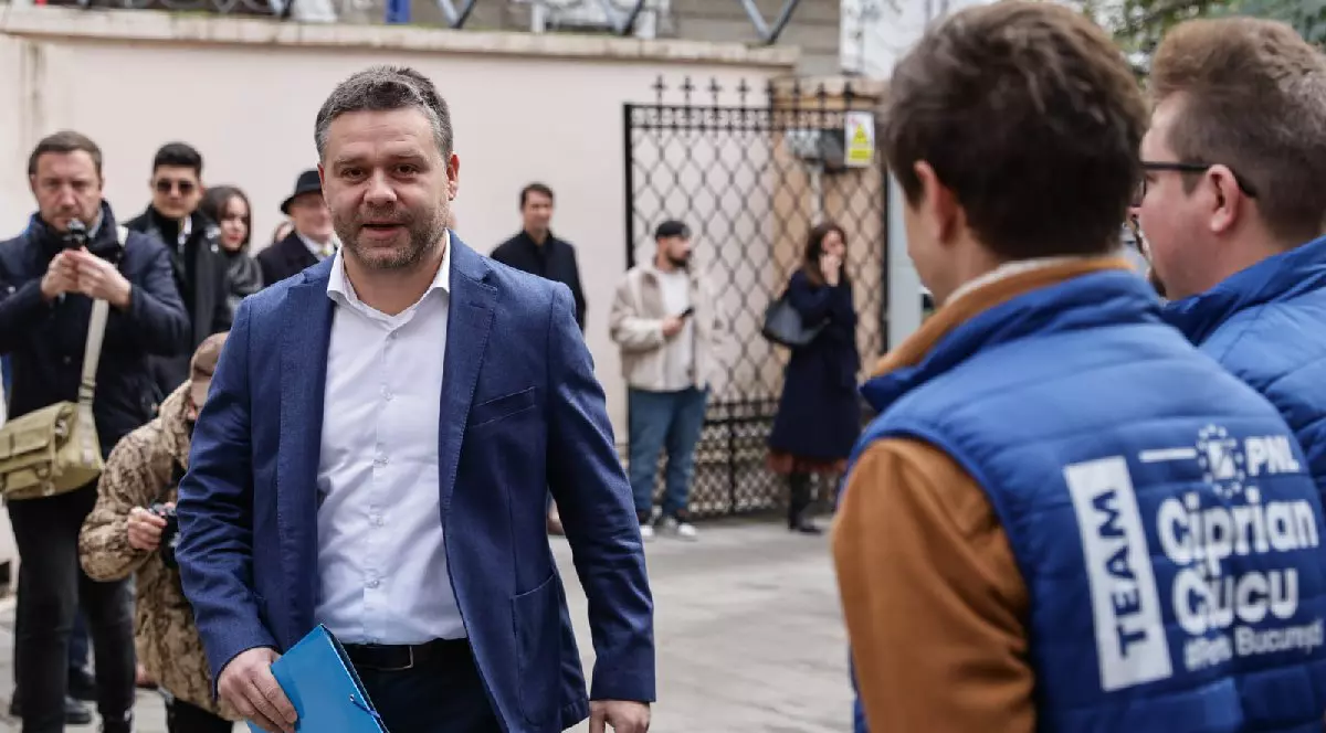 Ciprian Ciucu, cu un sacou albastru si camasa alba, cu un dosar albastru in mana, la depunerea candidaturii pentru Primăria Capitalei