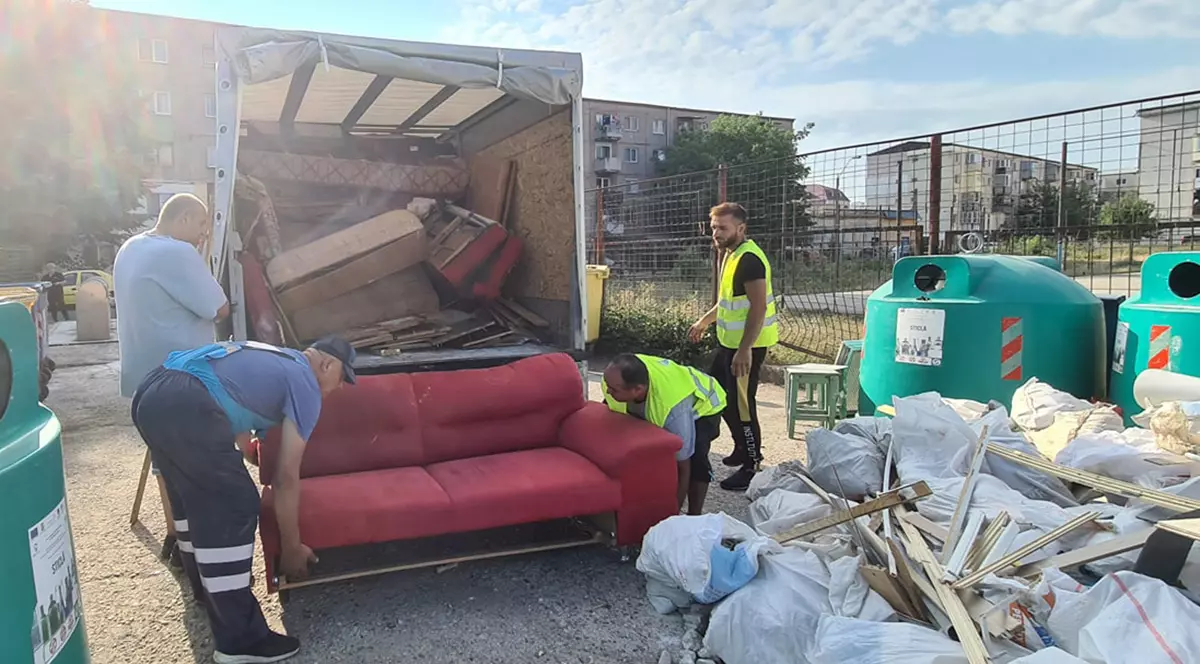 Bărbați care transportă deșeuri voluminoase