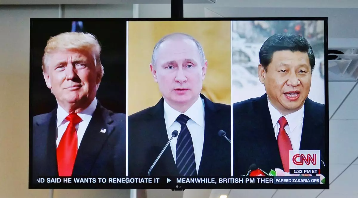 Un televizor pe CNN în care apar trei ferestre cu Donald Trump, în stânga, Vladimir Putin în centru, și Xi Jinping în dreapta
