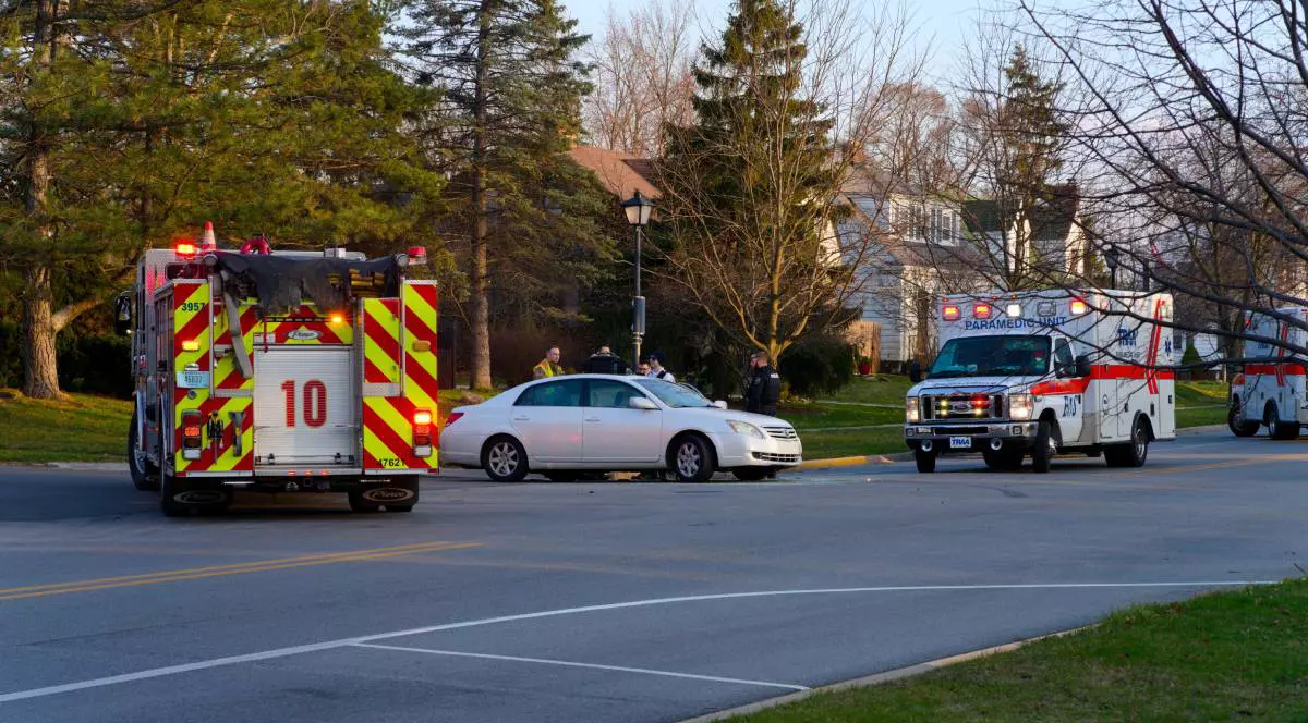 O ambulanță și o mașină de pompieri, parcate în fața unei case din Indiana, lângă o mașină. Pompierii i salvatorii discută cu un bărbat aflat în spatele mașinii