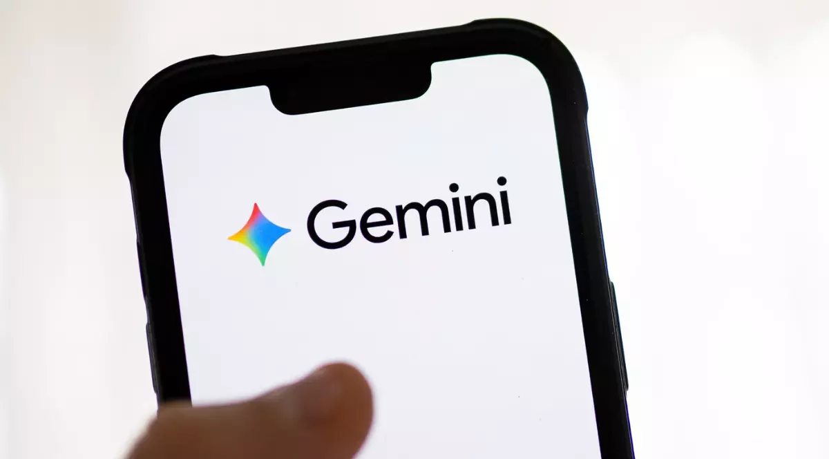 Imaginea prezintă un smartphone ținut în mână, pe al cărui ecran este afișat clar logo-ul și numele "Gemini". Sigla este reprezentată de o formă colorată (roșu, galben, albastru) alături de numele scris cu litere negre pe fundal alb, sugerând o aplicație sau un serviciu digital.