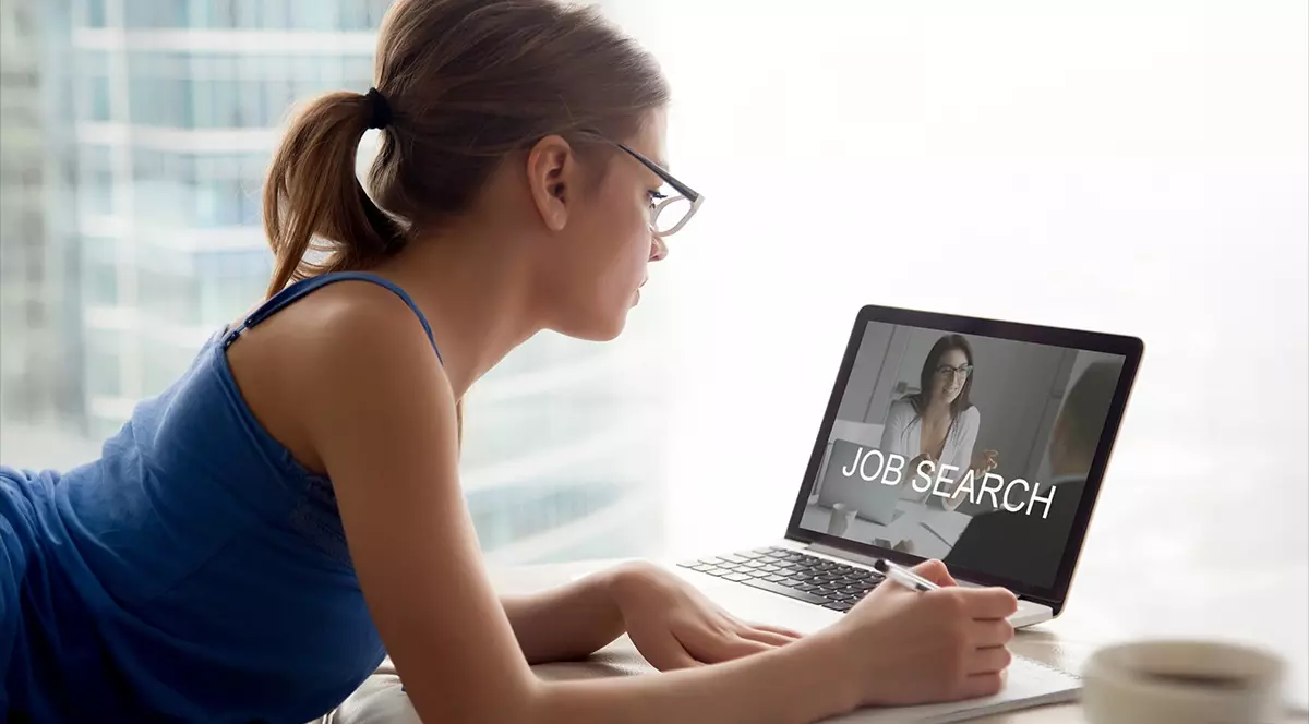 O tânără se uită la locuri de muncă pe calculator