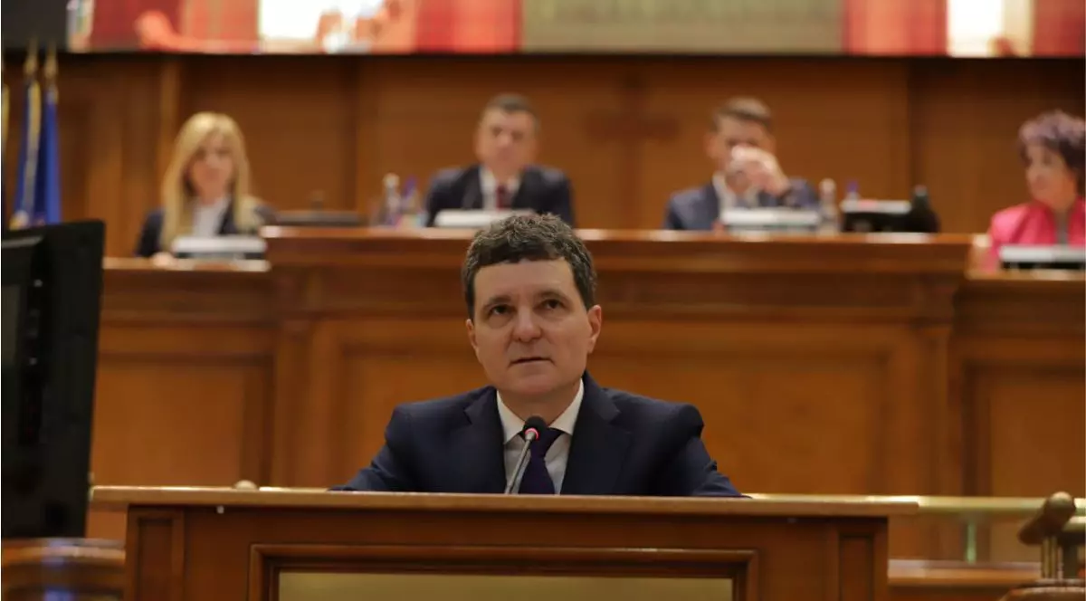 Nicușor Dan a prezentat miercuri, 26 noiembrie, Strategia Naționala de Apărare a Țării în fața Parlamentului, îmbrăcat într-un sacou negru, o cămașă albă și o cravată bleumarin, stând în spatele pupitrului Camerei Deputaților, privind puțin în sus