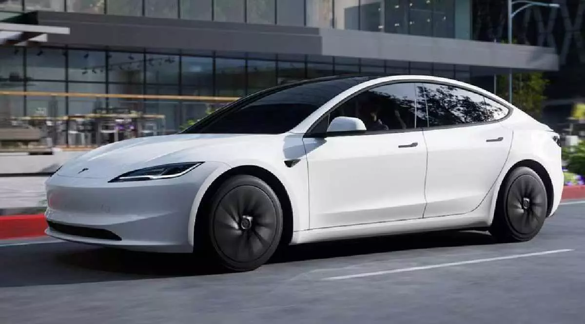 Tesla Model 3 Standard oprită pe stradă lângă o clădire.