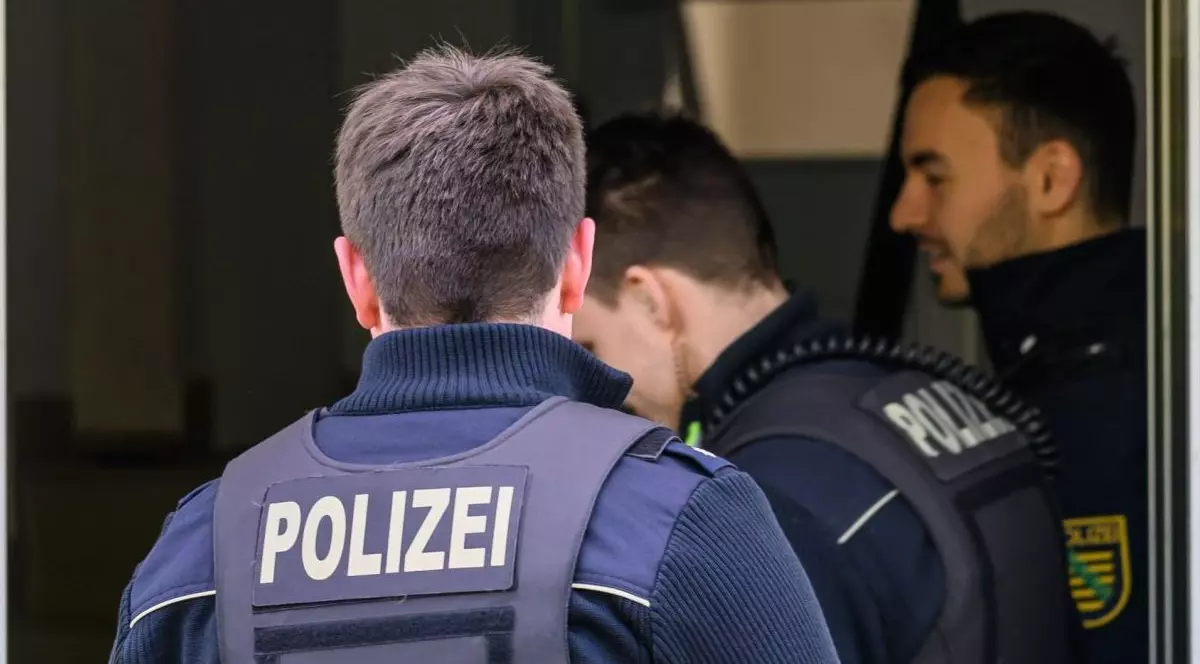 Ofițeri germani intră pe casa scărilor unei clădiri rezidențiale.