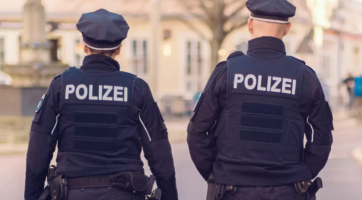 Doi polițiști, o femeie și un bărbat, care merg pe stradă.