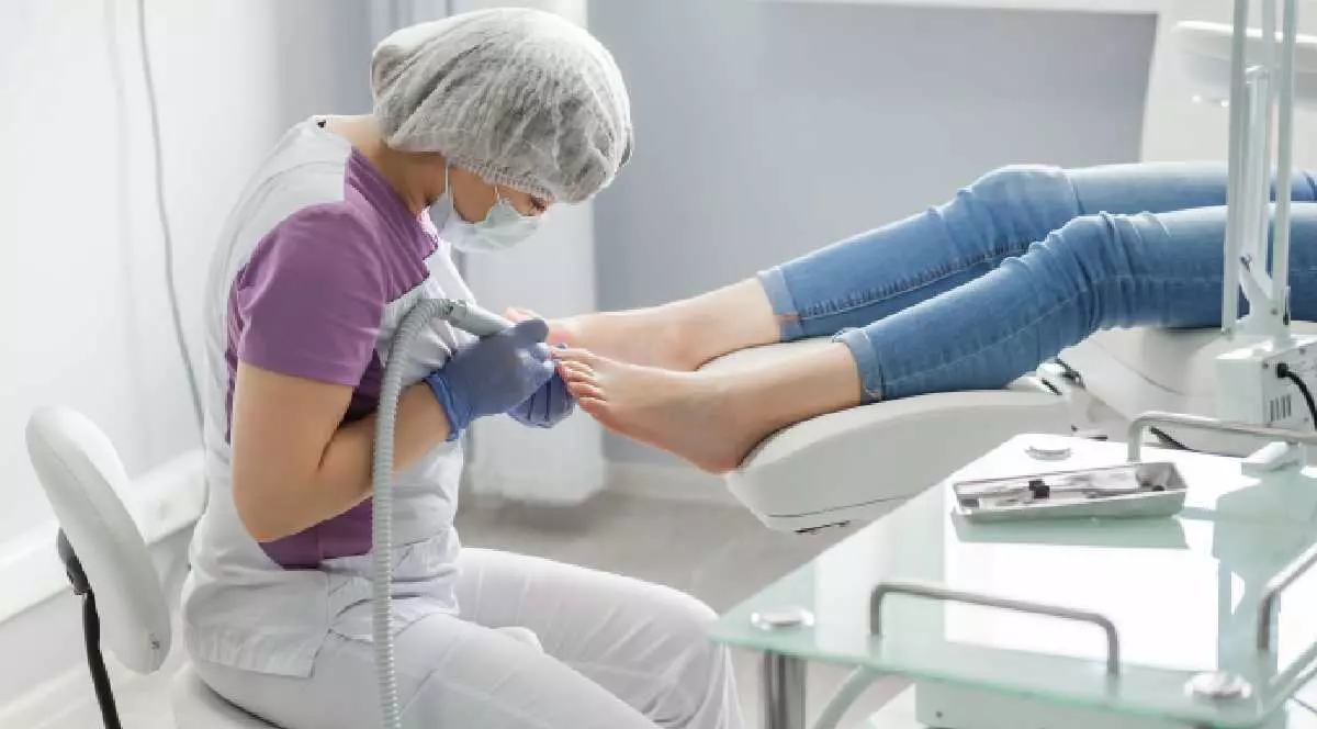 Un medic face tratament la picioare și la unghii.