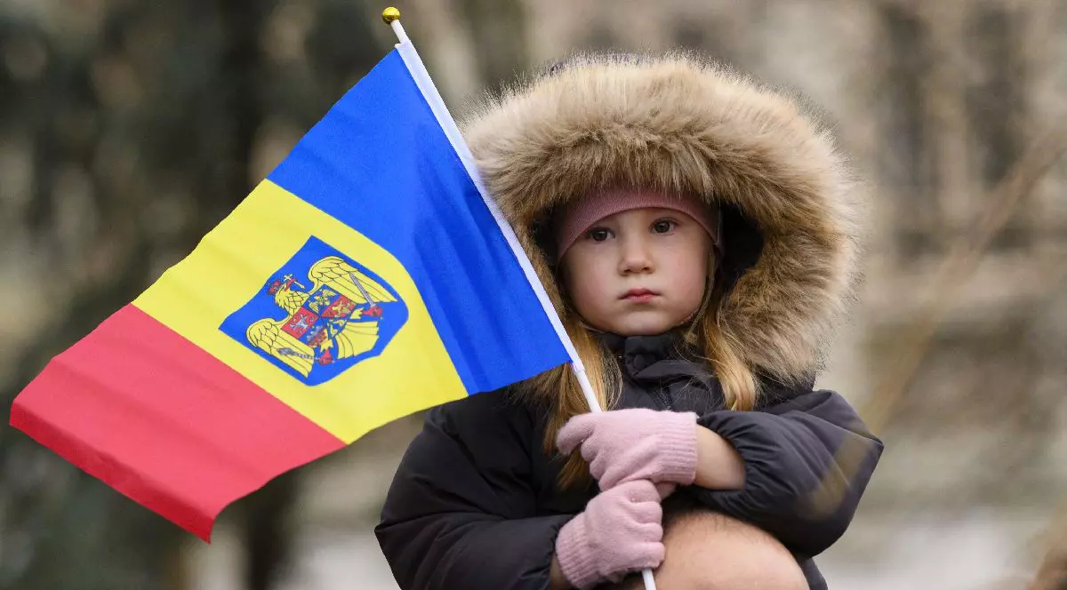 O fetita ce tine in maini un steag tricolor urmareste parada militara dedicata sarbatoririi Zilei Nationale, duminica, 1 decembrie 2024, in Bucuresti.