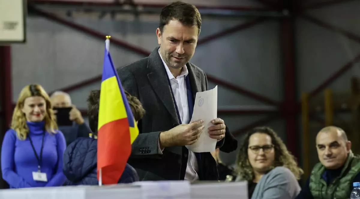 Fotografie cu Cătălin Drulă îmbrăcat într-un costum gri care votează într-o sală de sport