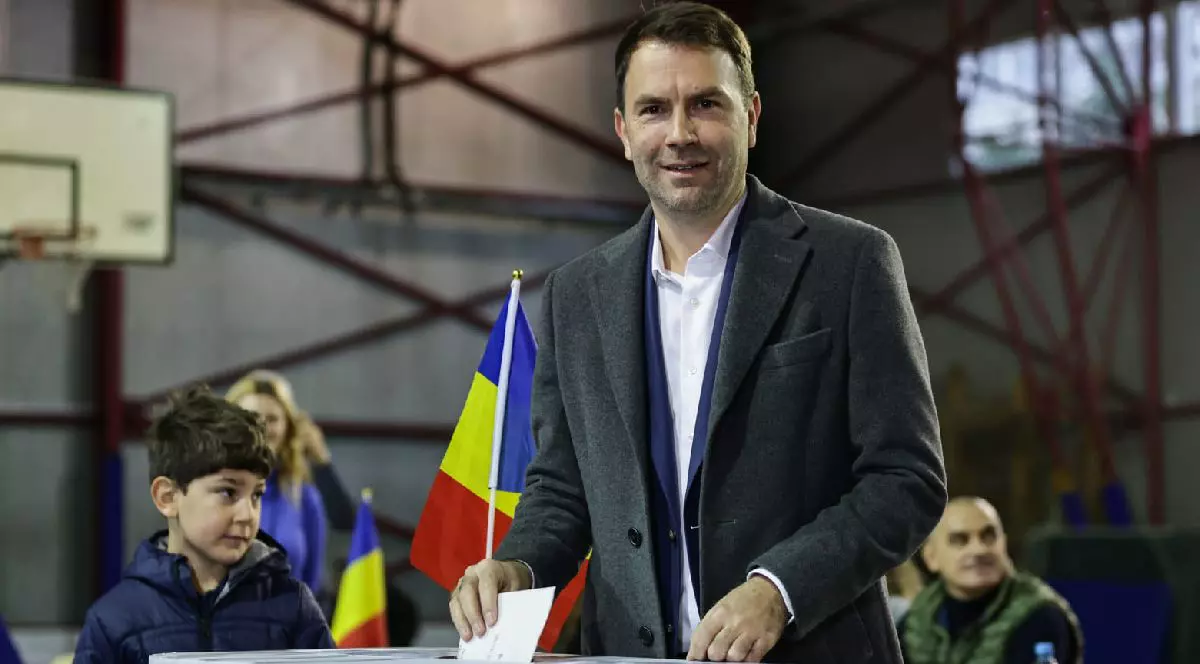 Fotografie cu Cătălin Drulă îmbrăcat într-un costum gri care votează într-o sală de sport