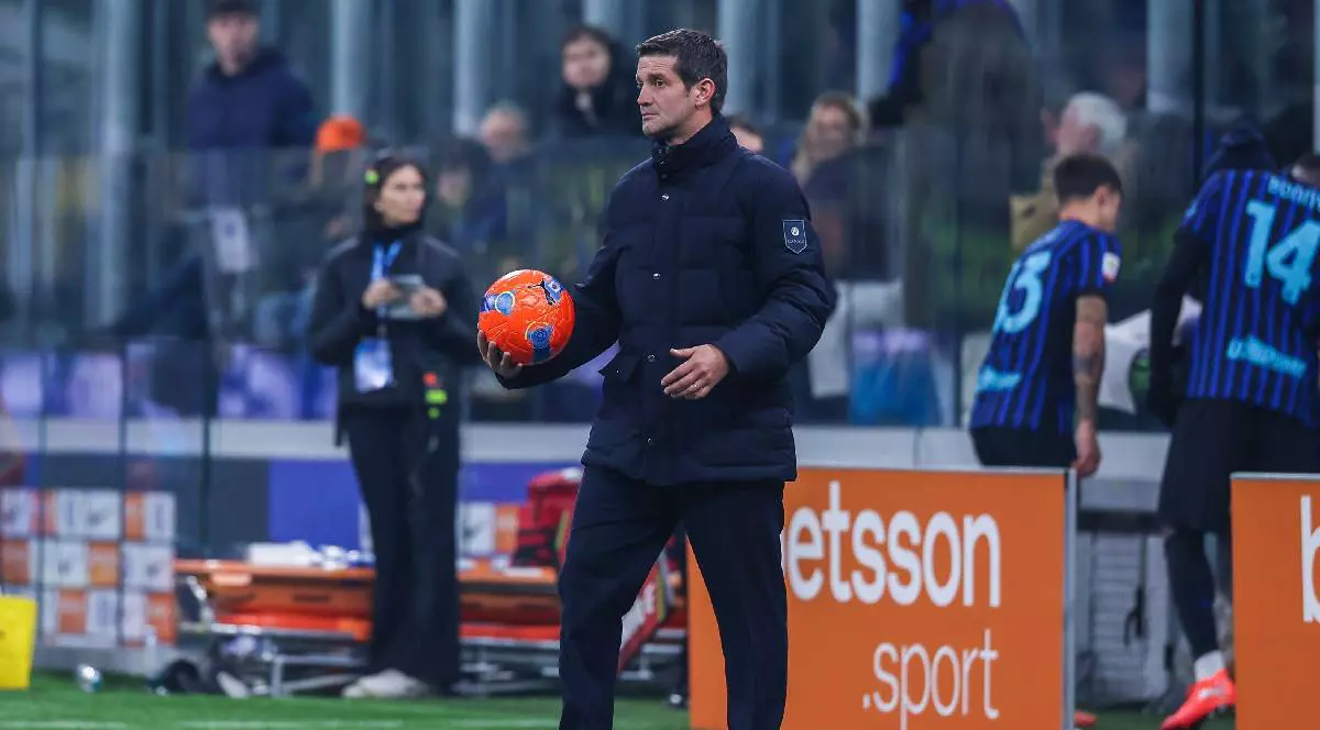 Cristi Chivu, pe marginea unui teren de fotbal, cu o minge de fotbal în mână