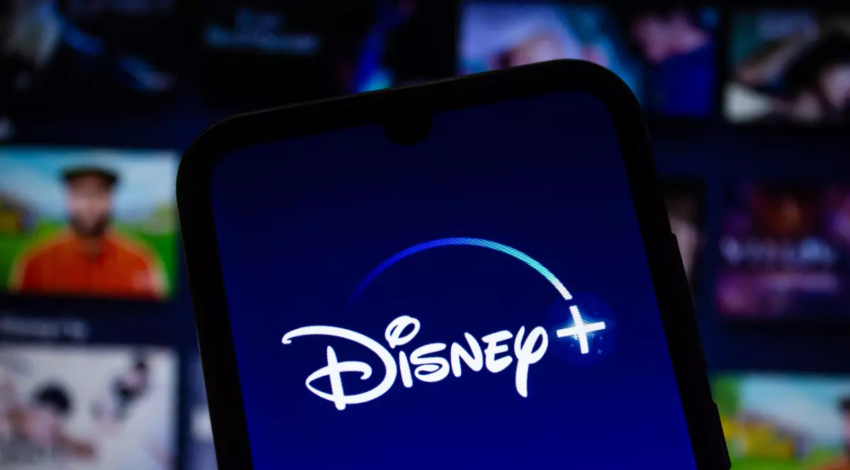 Logo=ul Disney scris cu alb, pe ecranul unui telefon mobil