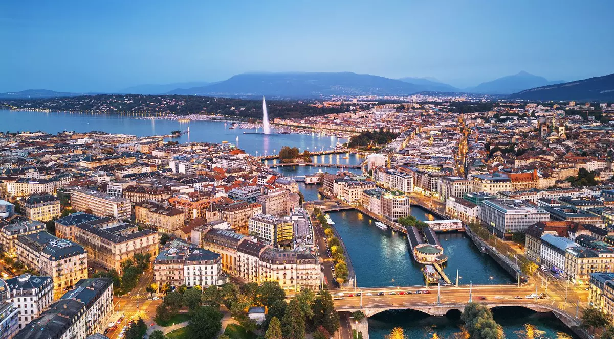 Vedere panoramică asupra orașului Geneva, Elveția, spre fântâna Jet d'Eau din Lacul Geneva, la apus.