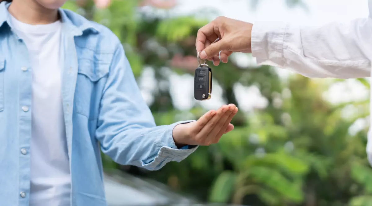 Proprietarul unei mașini îi oferă cheia autoturismului unei alte persoane