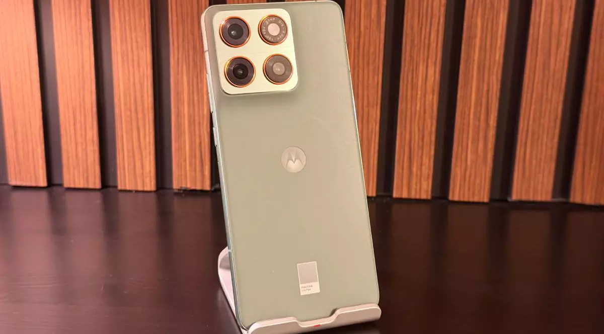 Poză cu spatele de culoare verde deschis al lui Motorola Edge 70, cu un fundal de lemn.