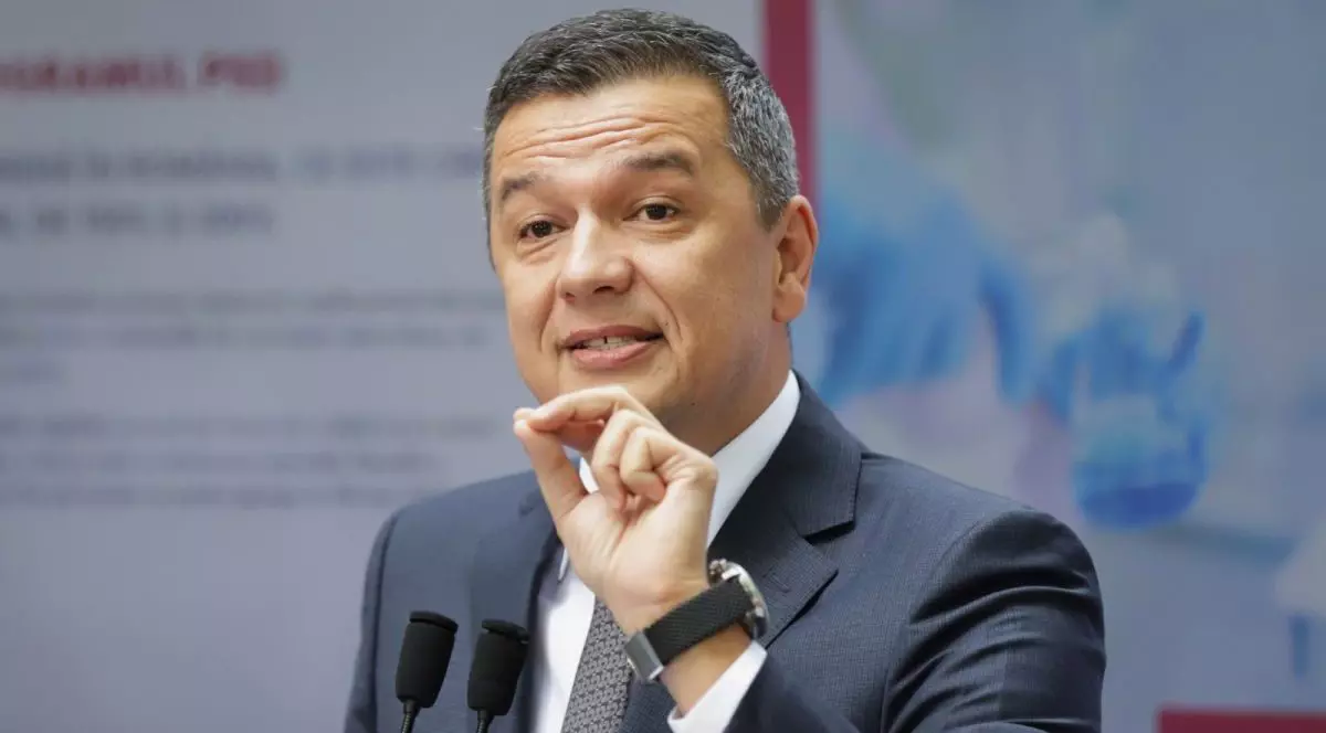 Președintele PSD, Sorin Grindeanu, îmbrăcat cu un sacou gri explică ceva și arată cu mâna, având trei degete lipite, 22 octombrie 2025