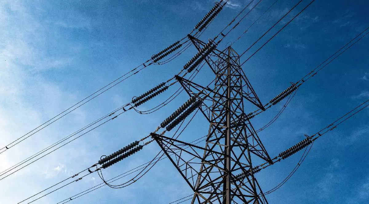 În imagine e un stâlp de electricitate uriaș, pe fundalul unui cer albastru