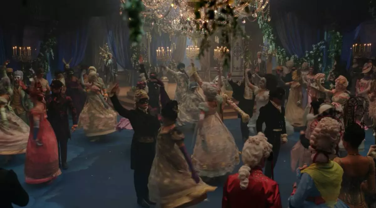 Imagine captura video din trailer Bridgerton sezonul 4, se vad multe persoane in costume renascentiste care participa la un bal mascat , unele danseaza, altele stau pe margine si privesc, intr-o sala mare, lumina difuza, frumos decoarata, se vad trei candelabre in spate care lumineaza, unul pe mijlocul salii