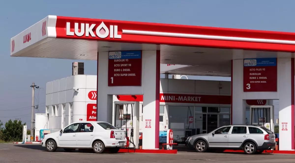 O benzinărie Lukoil din România, mașinile sunt așezate la pompă și șoferii alimentează